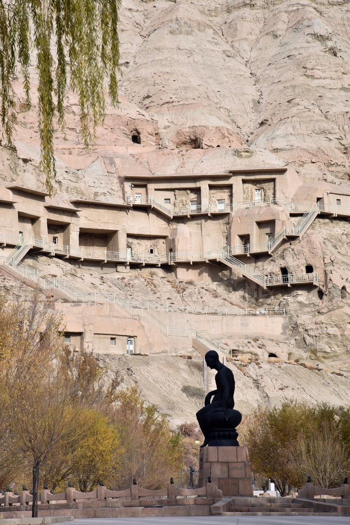 A statue of the Buddhist scholar and seer Kumarajiva (c. 344-413) sits in front of the Kizil Grottoes in Xinjiang. /IC