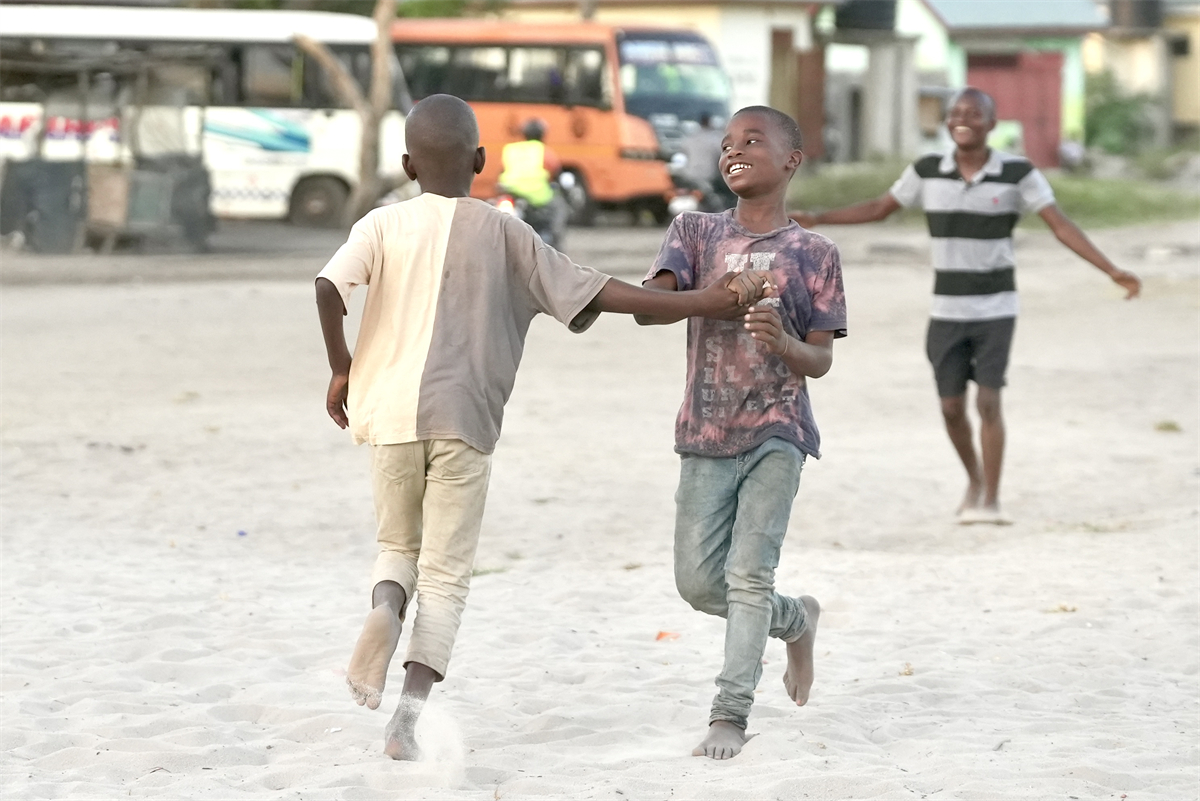 Barefooted youngsters enjoy a game of football despite the lack of a proper playing field or ball at a small village in Tanzania. /CGTN