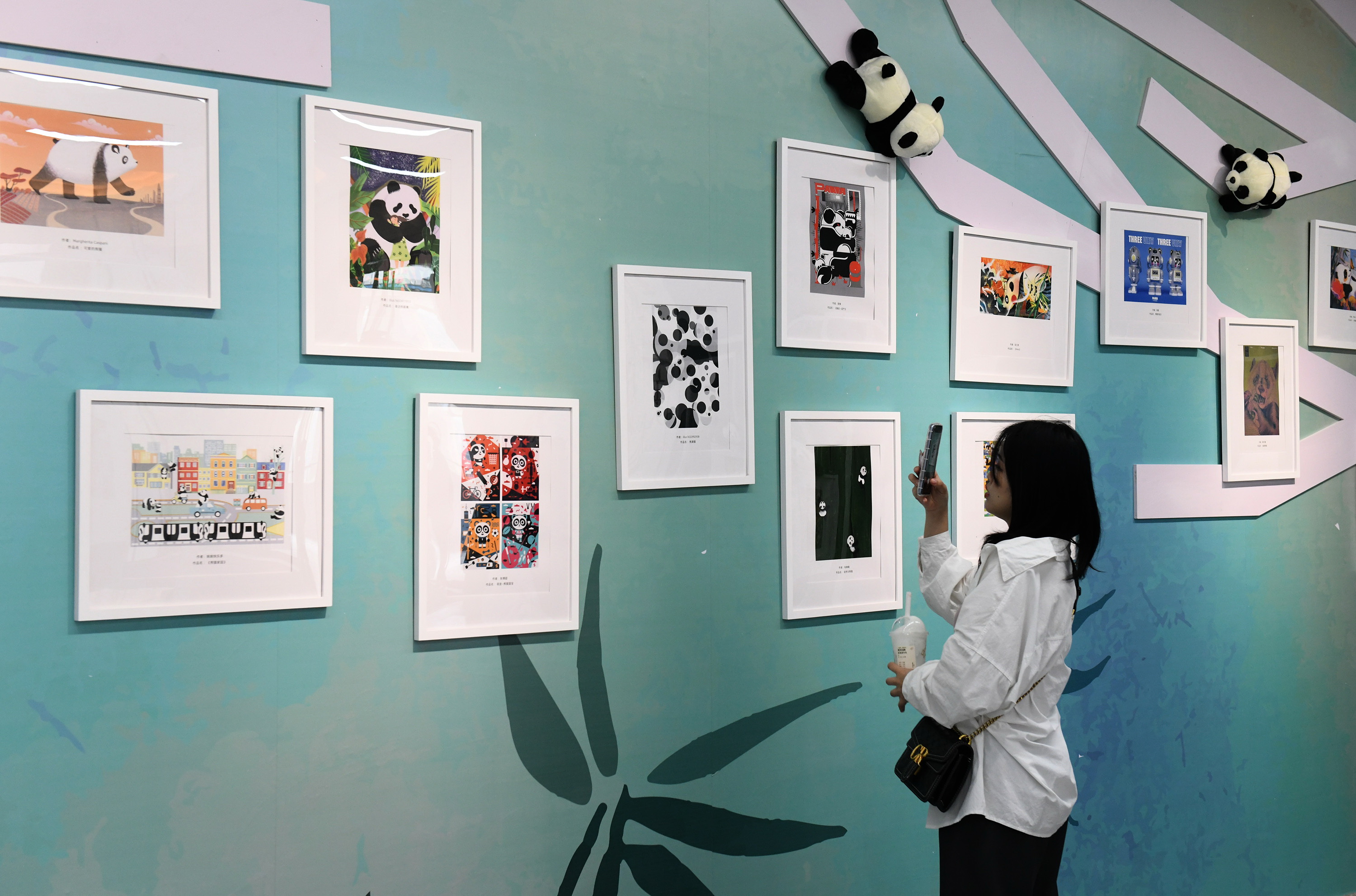 A photo taken on October 8, 2023 shows visitors taking photos with panda-themed illustrations at the exhibition in Chongqing, China. /CFP