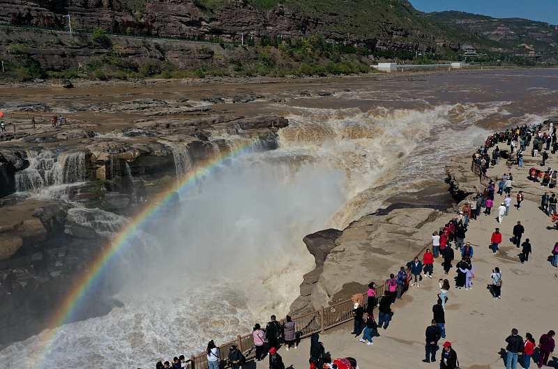 Visitors appreciate the spectacular view of a rainbow over the Hukou Waterfall scenic spot in Linfen City, Shanxi Province, October 9, 2023. /CFP