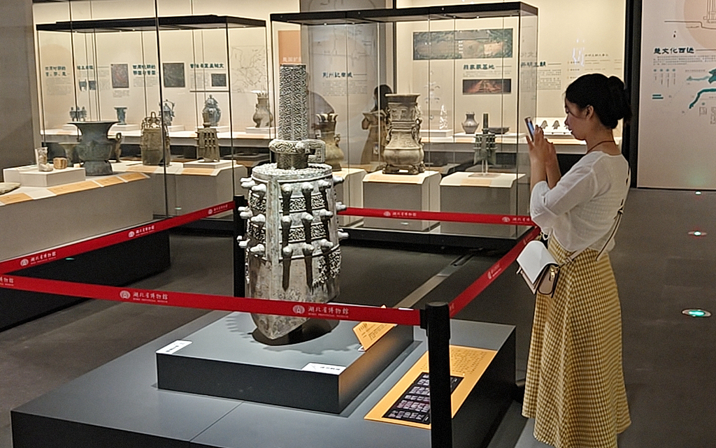 A photo taken on September 26, 2023 shows a visitor taking photos of a cultural relic displayed at the 