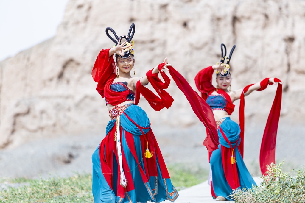 Performers dance against the backdrop of the Subash Buddhist Ruins in Kucha City, Xinjiang Uygur Autonomous Region, amid efforts to boost tourism to this ancient relic site. /IC