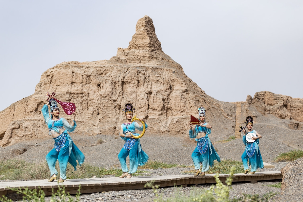 Performers dance against the backdrop of the Subash Buddhist Ruins in Kucha City, Xinjiang Uygur Autonomous Region, amid efforts to boost tourism to this ancient relic site. /IC