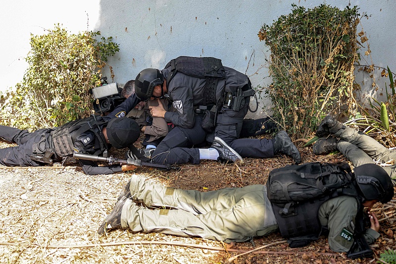 Israeli police and security forces assist a journalist taking cover during an alert for a rocket attack in Israel's southern city of Sderot near the border with Gaza Strip, October 12, 2023. /CFP