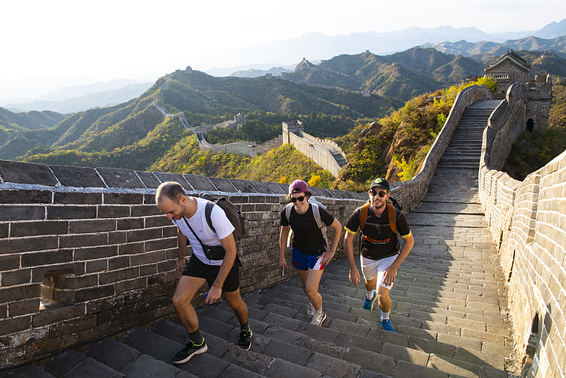 Visitors take in views of the surrounding countryside as they walk along the Jinshanling section of the Great Wall in Luanping County, Hebei Province, October 10, 2023. /CFP