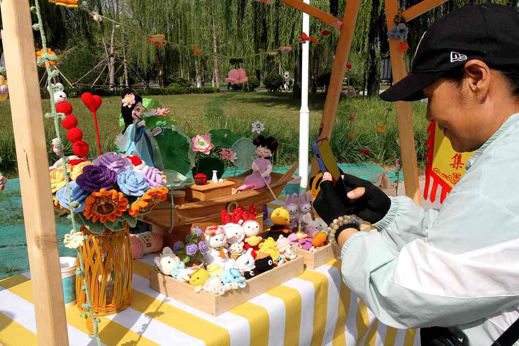 A visitor selects knitted products at the Autumn Yellow River Fair in Ji'nan, Shandong Province, on October 11, 2023. /CFP