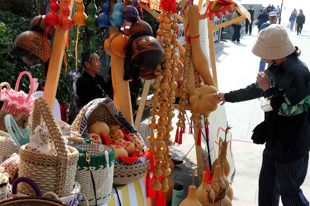 A visitor looks at pyrography gourd products at the Autumn Yellow River Fair in Ji'nan, Shandong Province, on October 11, 2023. /CFP