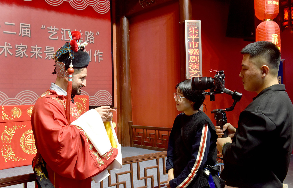 An Arabic artist dressed in a Jiangxi Opera costume is interviewed by local media in Leping City, Jiangxi Province. /CFP