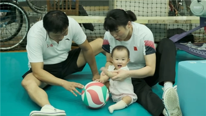 Ding Xiaochao (L) and Zhao Meiling (R) of China take care of their daughter Ding Xiyue. /CMG