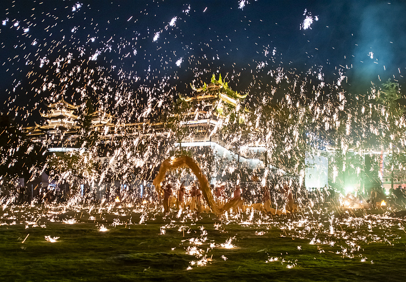 A molten-iron throwing show and a dragon dance performance are staged simultaneously during the 8th International Festival of the Intangible Cultural Heritage in Chengdu City, Sichuan Province, October 13, 2023. /CFP