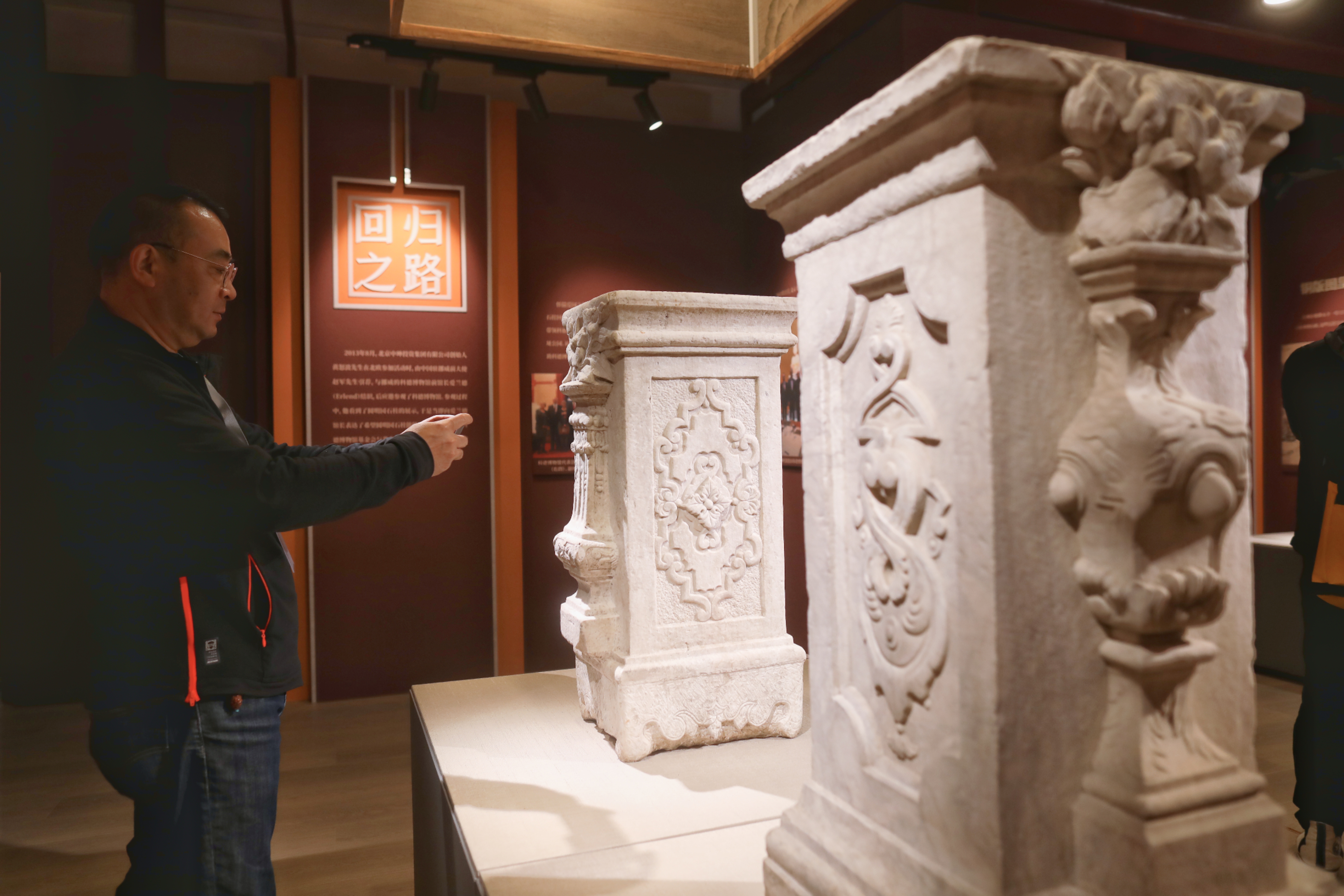 A visitor takes a photo of ancient stone columns on display at the Old Summer Palace in Beijing, October 13, 2023. /IC