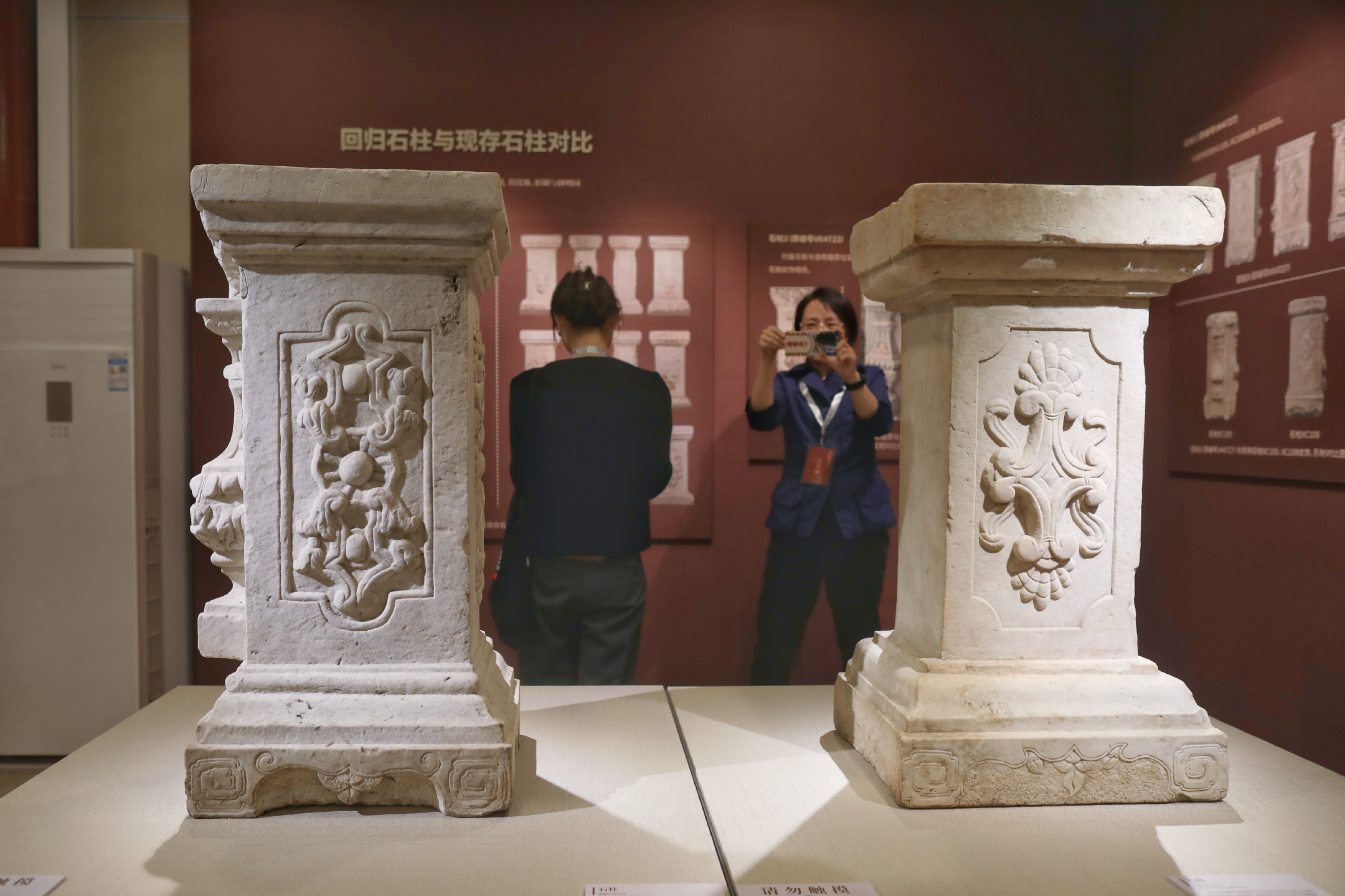 A visitor takes a photo of ancient stone columns on display at the Old Summer Palace in Beijing, October 13, 2023. /IC