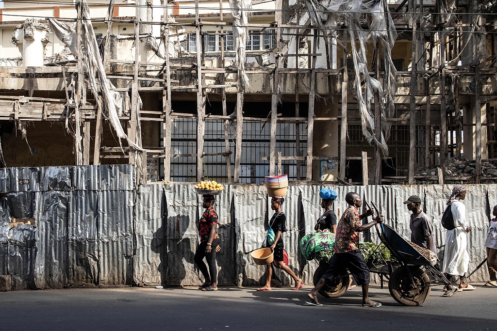 People walk along one of the main roads in the business district of Freetown, capital of Sierra Leone, April 15, 2022. /CFP