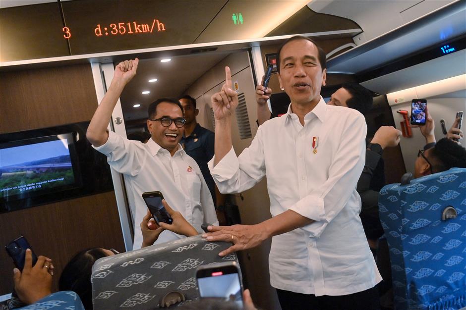 Indonesian President Joko Widodo (R) and Minister of Transportation Budi Karya Sumadi (L) point towards a display showing the speed of the Jakarta-Bandung high-speed train, September 13, 2023. /AFP