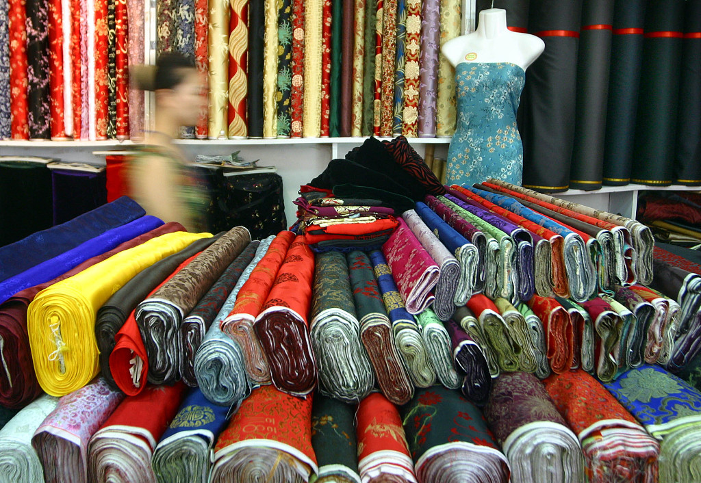 A file photo shows rolls of silk textiles stacked in a fabric store. /CFP