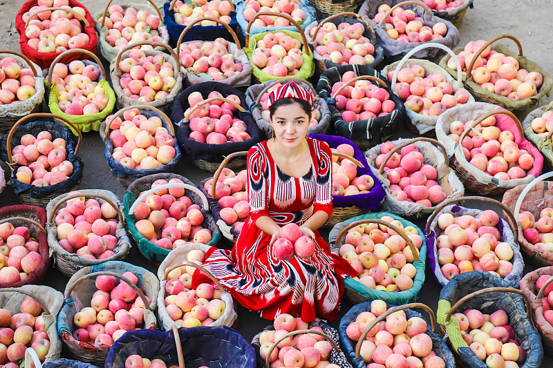 A woman displays apples in Xinjiang Uygur Autonomous Region. /CFP