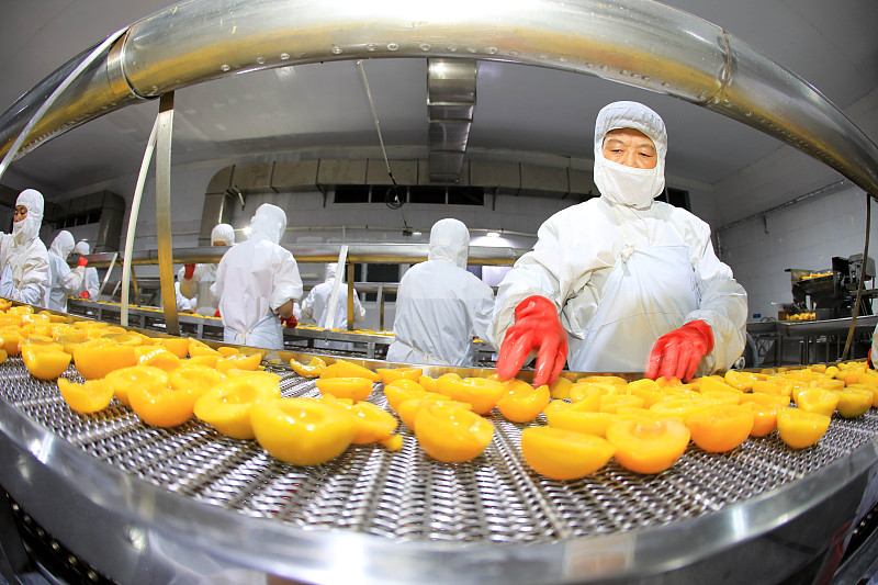 Workers process fresh peaches at a factory in Huaibei City, Anhui Province. /CFP