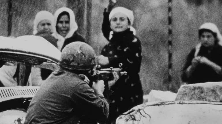 An Israeli soldier aims his rifle at a Palestinian woman holding a rock during a demonstration in which one Palestinian youth was shot dead in Gaza, on February 29, 1988 /Reuters