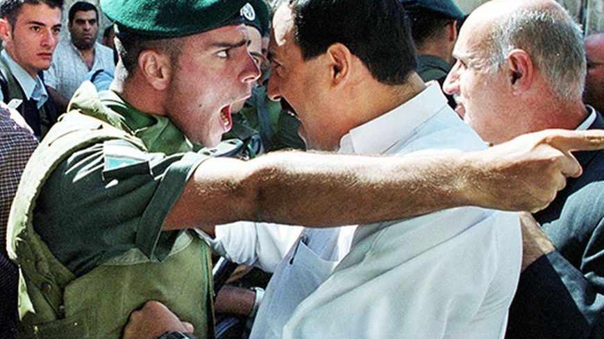 An Israeli border policeman and a Palestinian man scream at each other face-to-face in the Old City of Jerusalem, Oct. 13, 2000. /Reuters