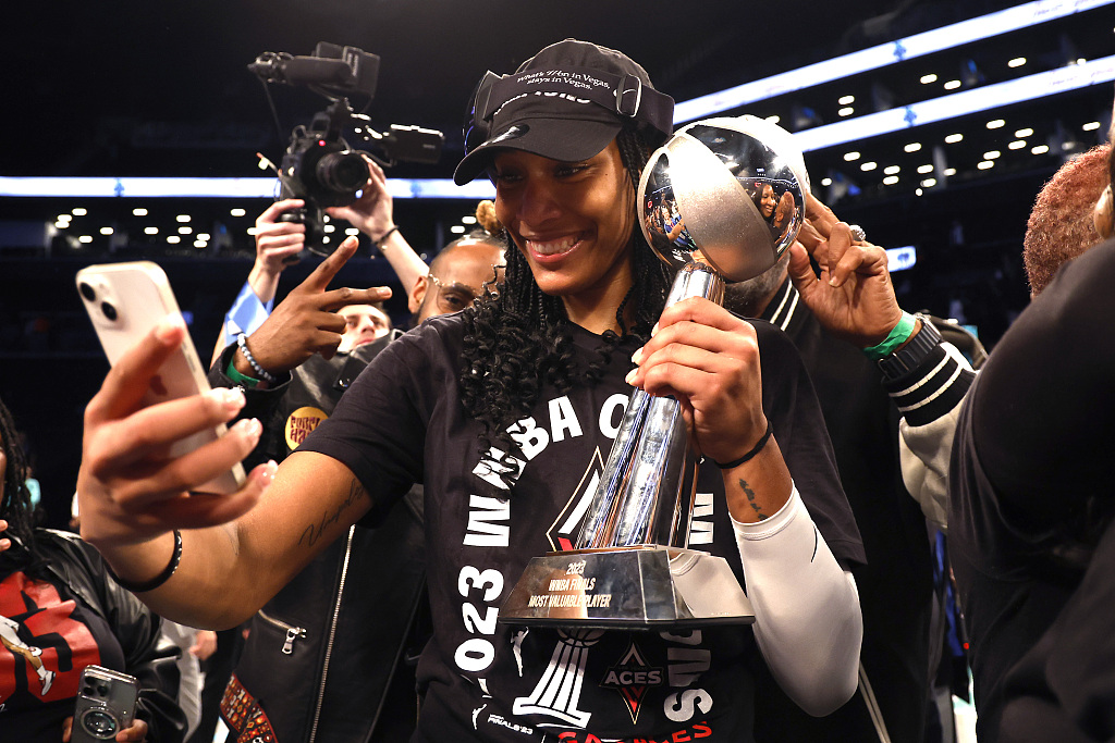 A'ja Wilson of the Las Vegas Aces holds her MVP trophy while taking a selfie at Barclays Center in New York, U.S., October 18, 2023. /CFP