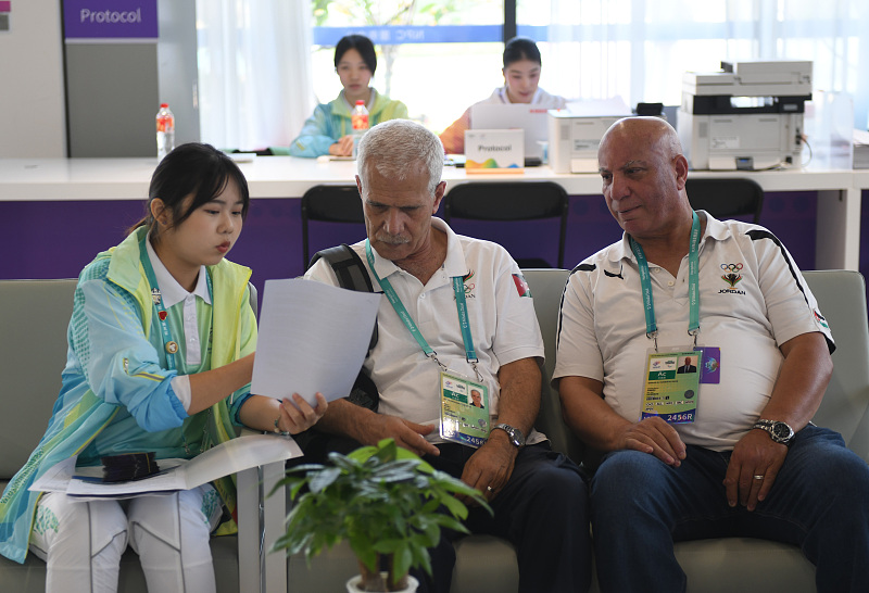 A volunteer introduces the transport information at the Asian Paralympic Games Village to visiting sports staff in Hangzhou, Zhejiang Province, October 16, 2023. /CFP