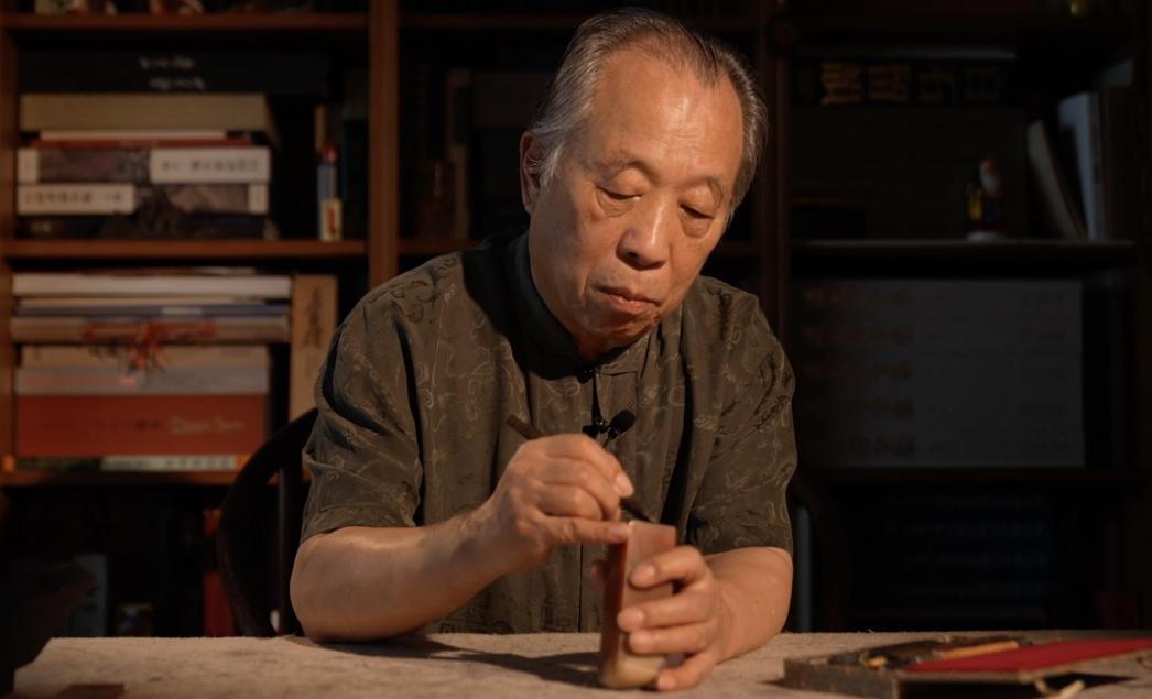 Artist Guo Shifu is engraving a seal. /CGTN