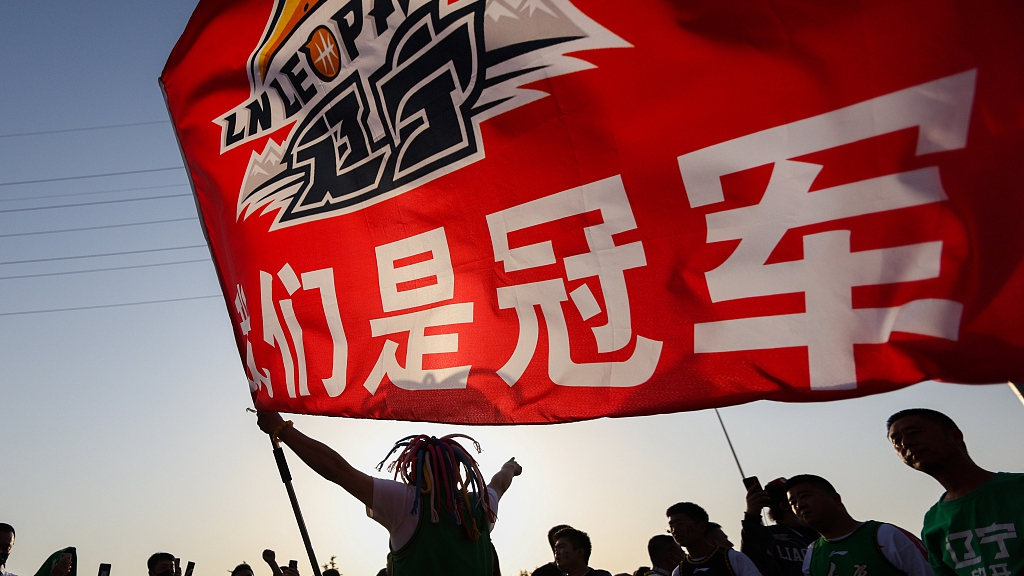 A Liaoning Flying Leopards fan waves a flag to celebrate their CBA title in Zhejiang Province, China, May 16, 2023. /CFP