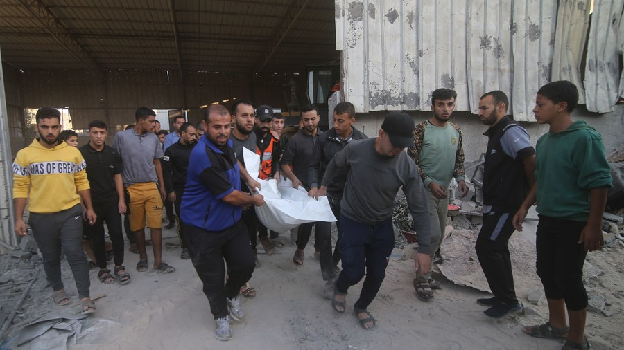 People remove the body of a victim from a building destroyed in Israeli airstrikes in the southern Gaza Strip city of Rafah, October 15, 2023. /Xinhua