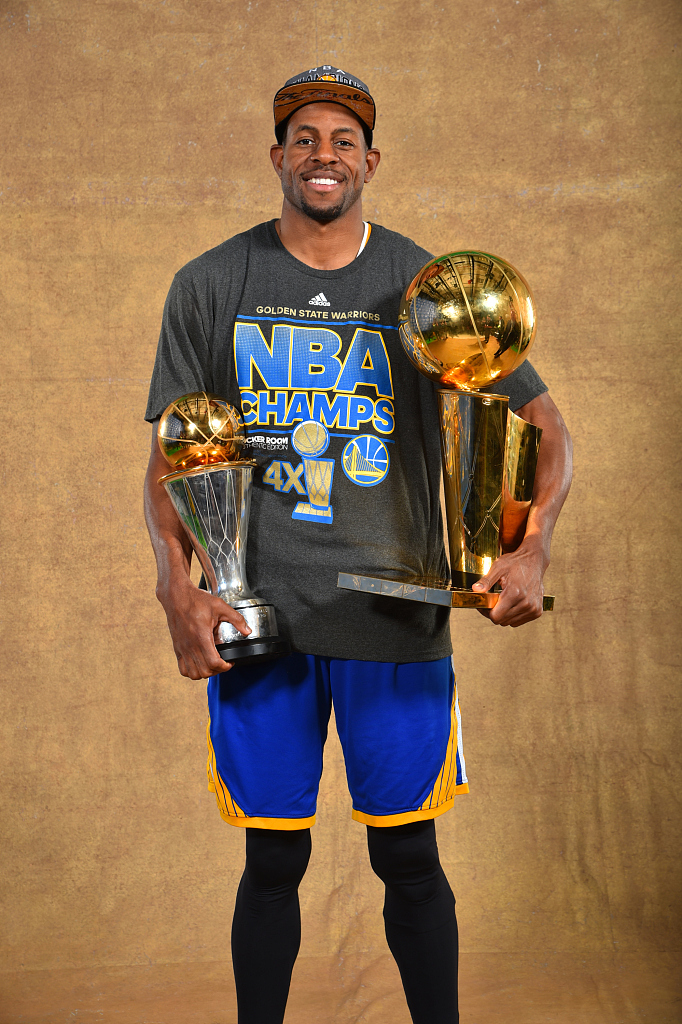 Andre Iguodala of the Golden State Warriors poses with the Larry O'Brien NBA Championship Trophy and the Bill Russell NBA Finals Most Valuable Player Trophy after the 105-97 win in Game 6 of the NBA Finals against the Cleveland Cavaliers at Quicken Loans Arena in Cleveland, Ohio, June 16, 2015. /CFP