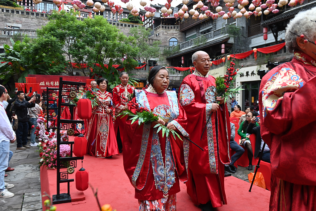 Photo shows elderly couples walking down the aisle wearing traditional Chinese wedding attire in Chongqing, October 19, 2023. /CFP