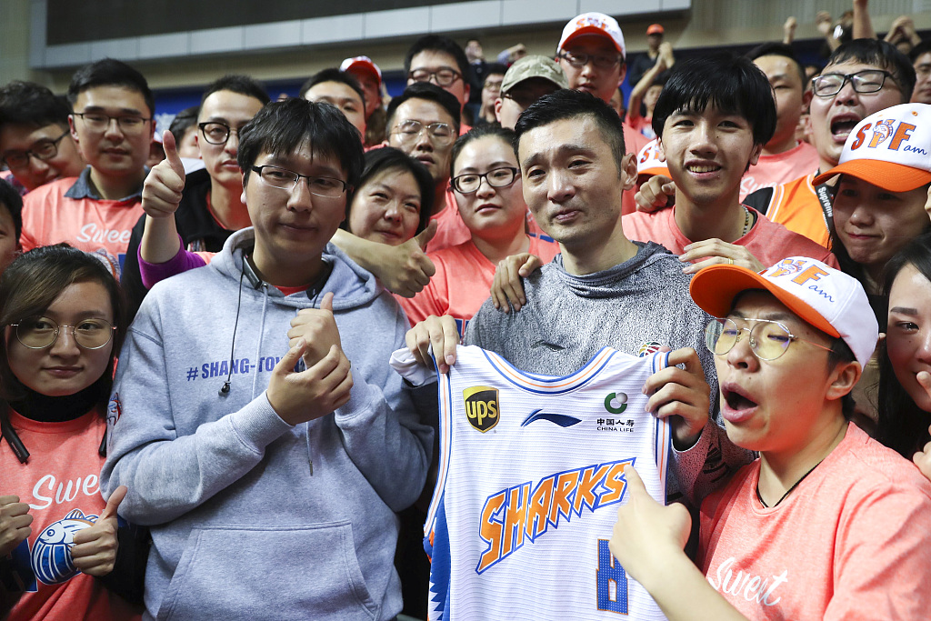 Liu Wei (#8) of the Shanghai Sharks poses with supporters after his final game in east China's Shanghai Municipality, March 19, 2019. /CFP