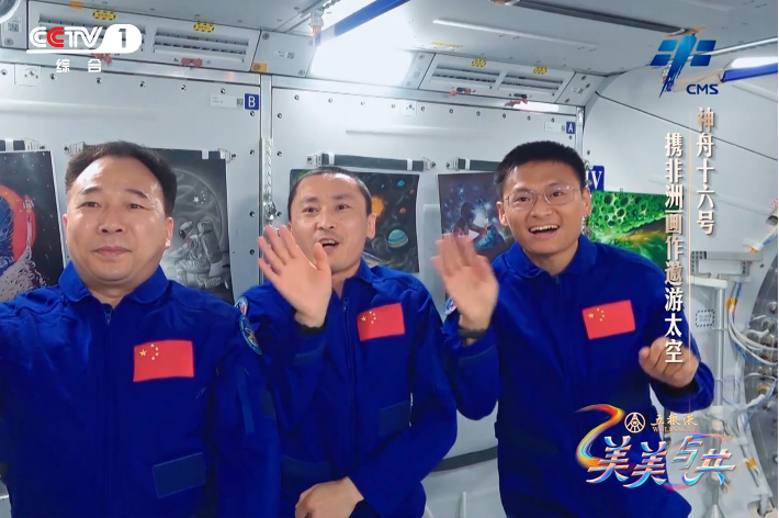 Chinese astronauts Jing Haipeng (L), Zhu Yangzhu (M) and Gui Haichao (R) waving to audiences from the China Space Station in a video address during China Media Group's program 