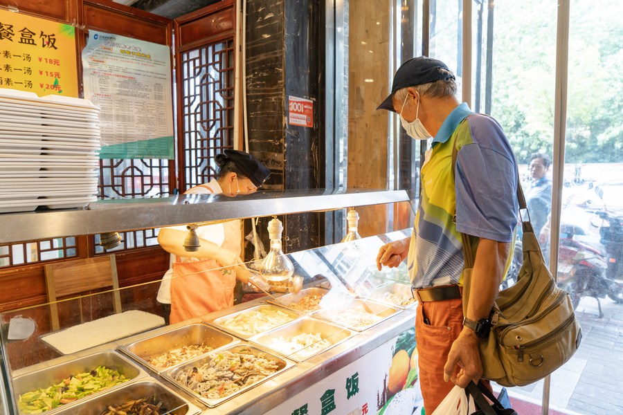 An elderly man buys food inside a community canteen in Luyang District of Hefei, capital of east China's Anhui Province, September 29, 2022. /Xinhua