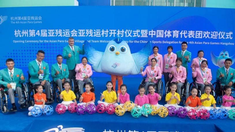 Members of Chinese Sports delegation pose with children and Feifei, the mascot of the 4th Asian Para Games, during the opening ceremony for the 4th Asian Para Games Village and team welcome ceremony for the Chinese Sports Delegation in Hangzhou, east China's Zhejiang Province, October 16, 2023. /Xinhua