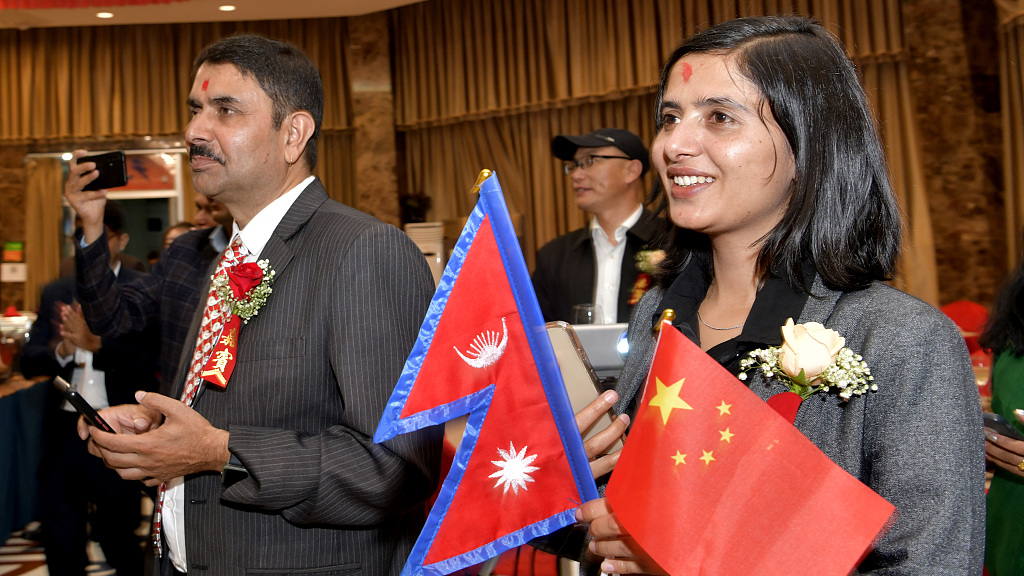 A Nepalese attendee holds Chinese and Nepalese flags at a bilateral social event in Lhasa, southwest China's Xizang Autonomous Region, October 7, 2023. /CFP