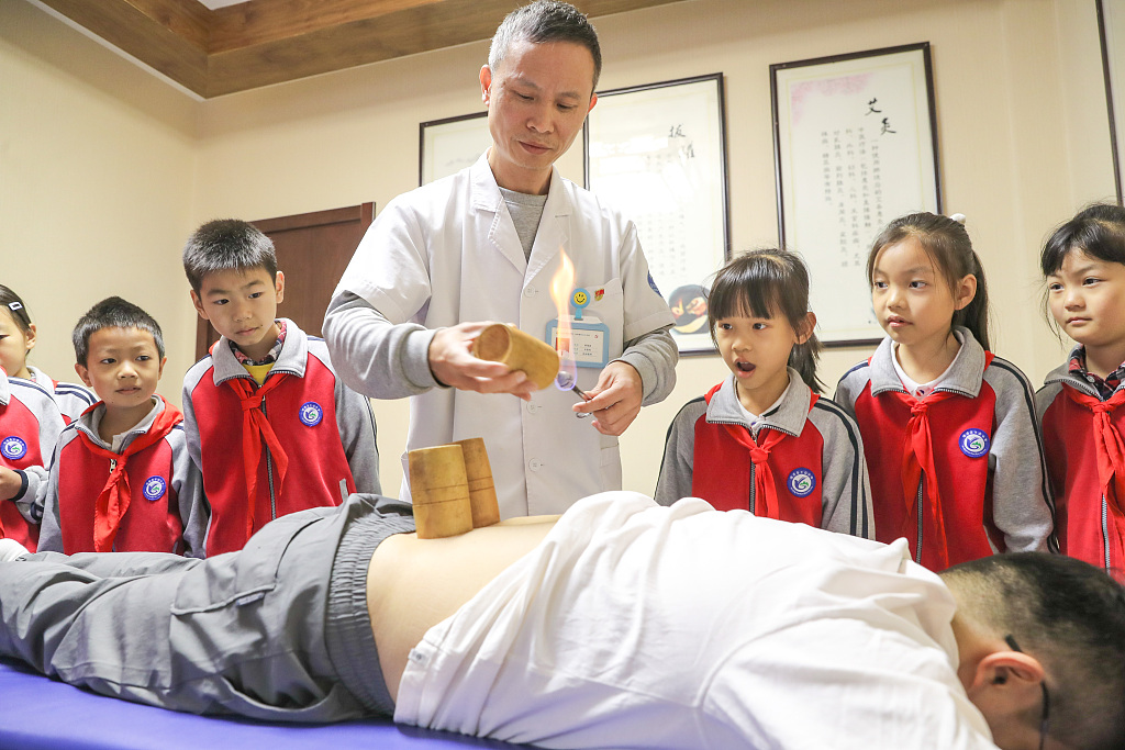 Students watch a demonstration of cupping therapy, a traditional Chinese method of healthcare, at a health center in Huzhou, east China's Zhejiang Province, October 20, 2023. /CFP