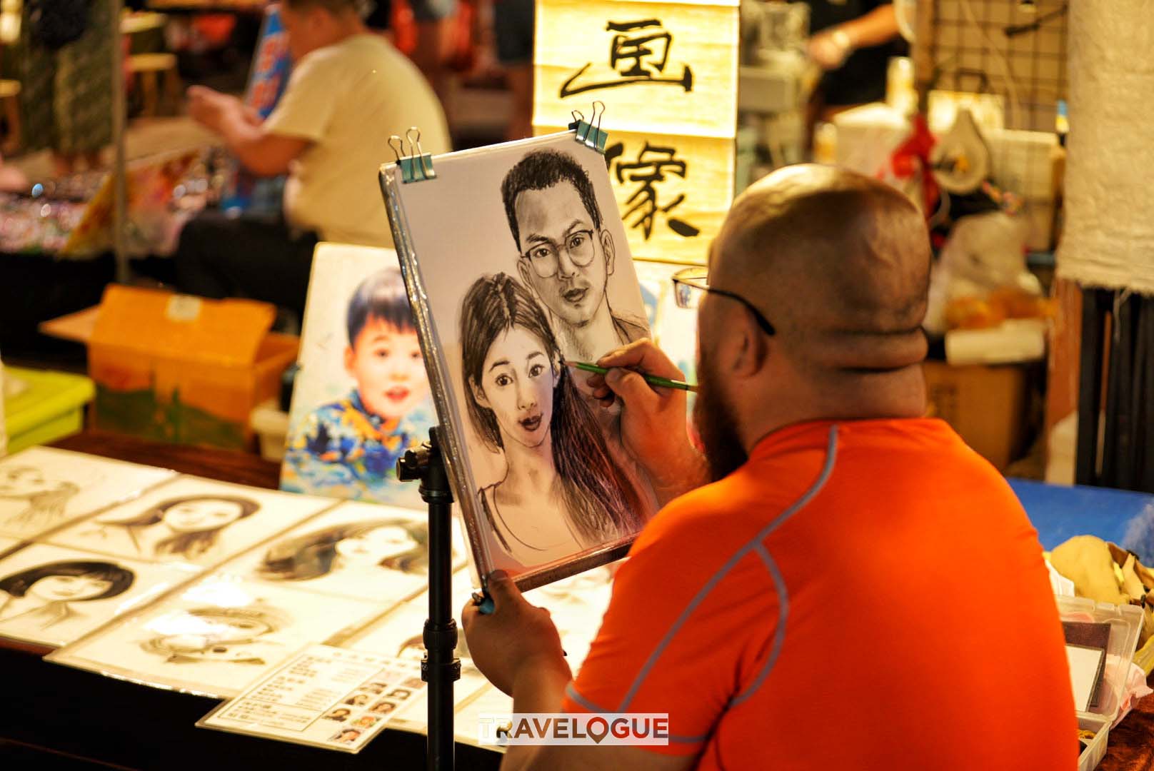 A folk artist draws a painting for tourists at the Star Night Market in Xishuangbanna, Yunnan Province. /CGTN