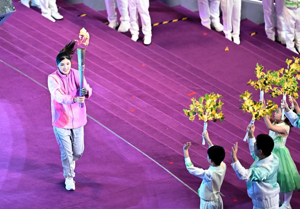 Xu Jialing (L) of China holds the torch at the opening ceremony of the fourth Asian Para Games at the Olympic Sports Centre Stadium in Hangzhou, east China's Zhejiang Province, October 22, 2023. /Xinhua