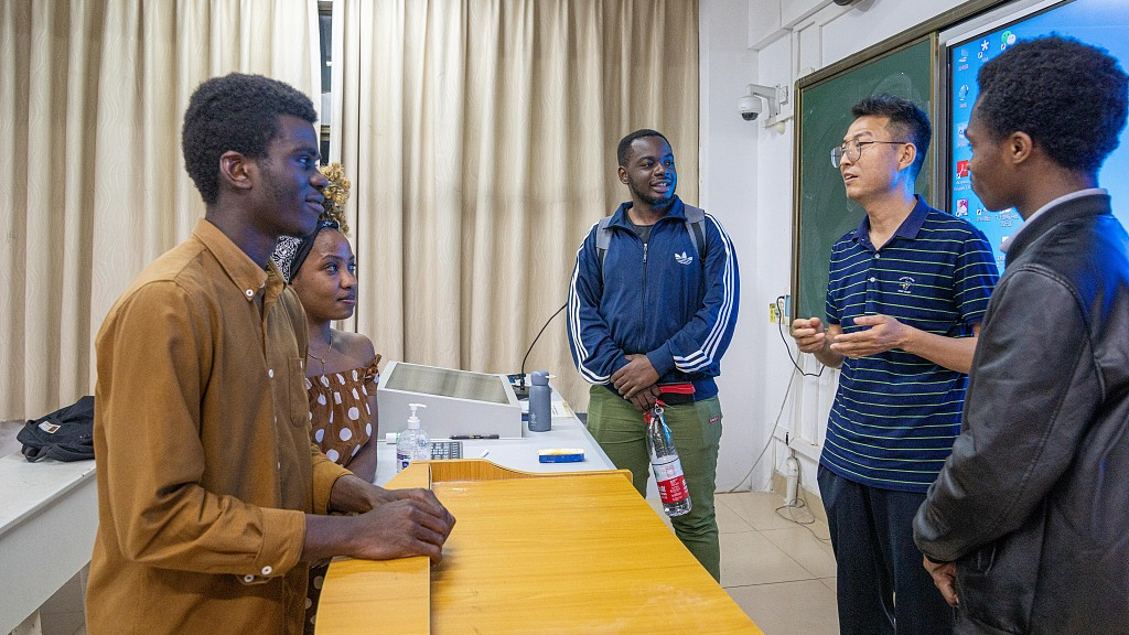 Clinical medicine students in Hainan Medical University talk to their professor after class, Haikou City, south China's Hainan Province, March 9, 2023. /CFP