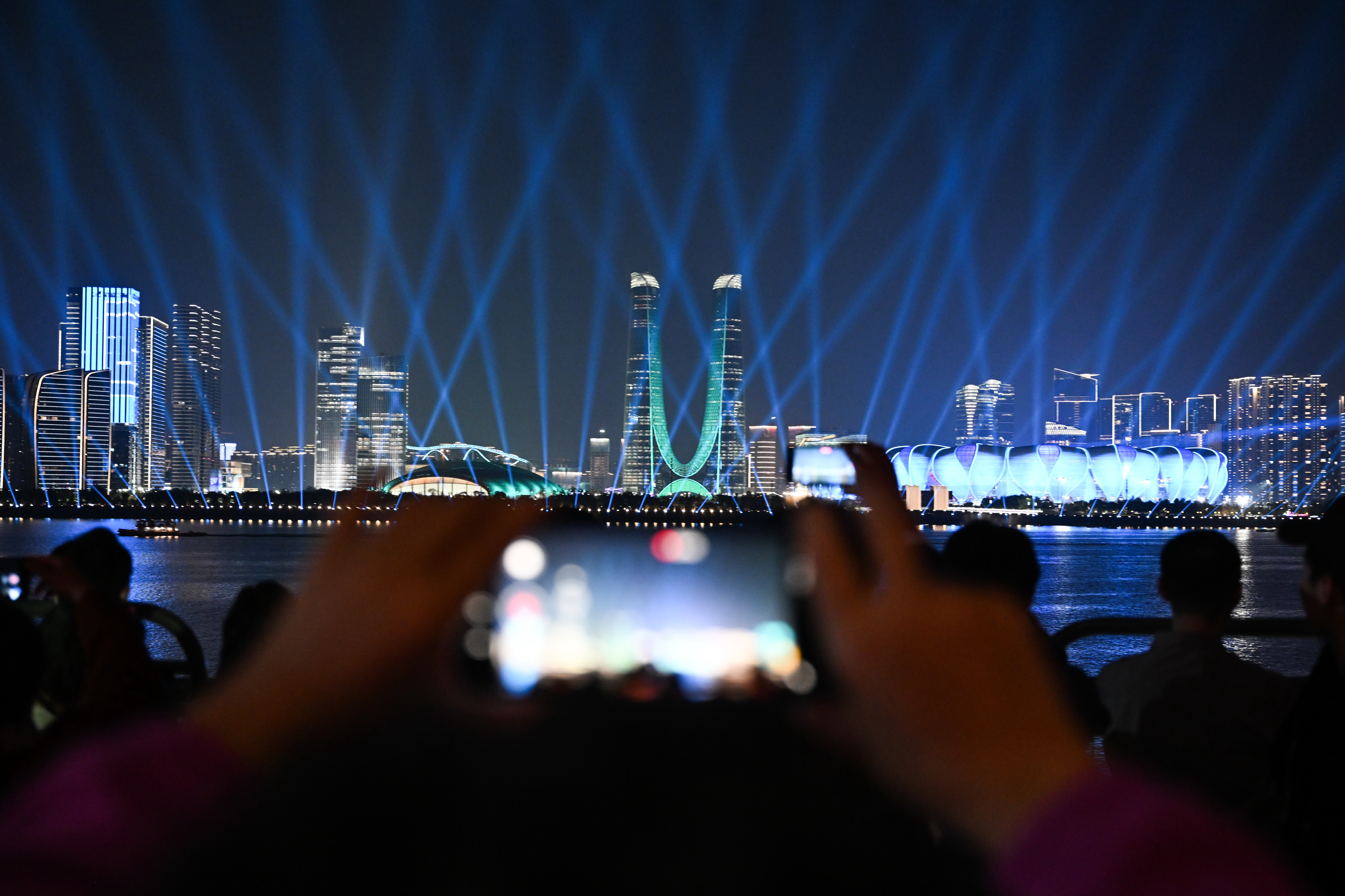 Visitors take photos to capture a beautiful light show during the opening of the 4th Asian Paralympic Games in Hangzhou City, Zhejiang Province, October 22, 2023. /CFP