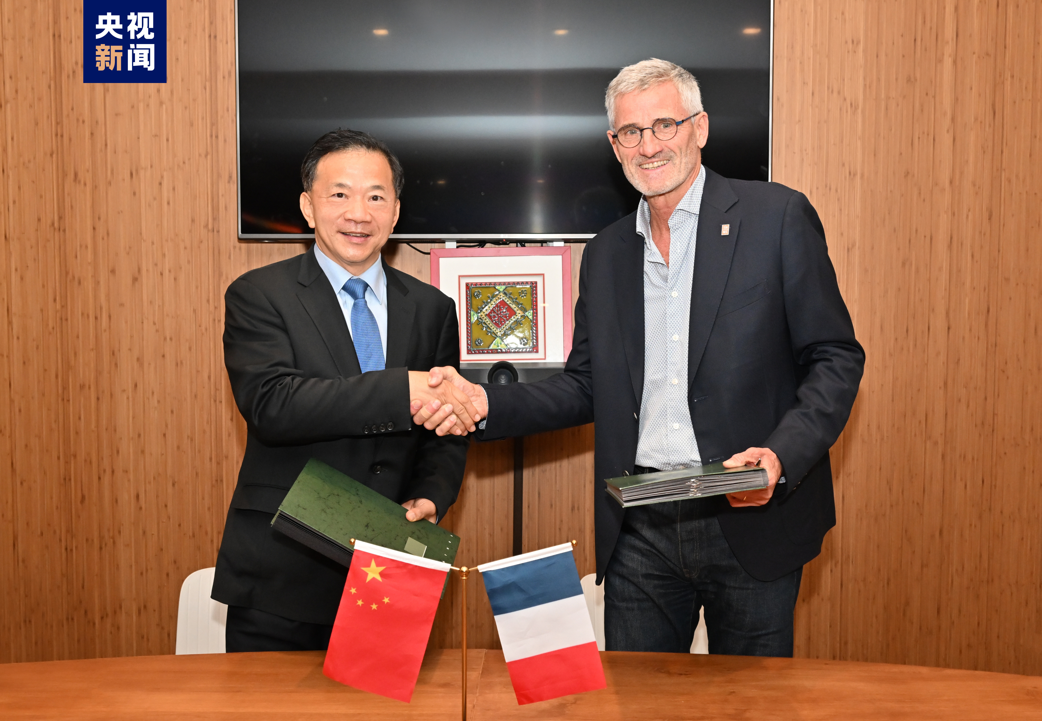 Shen Haixiong (L), president of China Media Group, and Gilles Moretton, president of the French Tennis Federation, shake hands after signing a memorandum of cooperation, October 23, 2023. /CMG