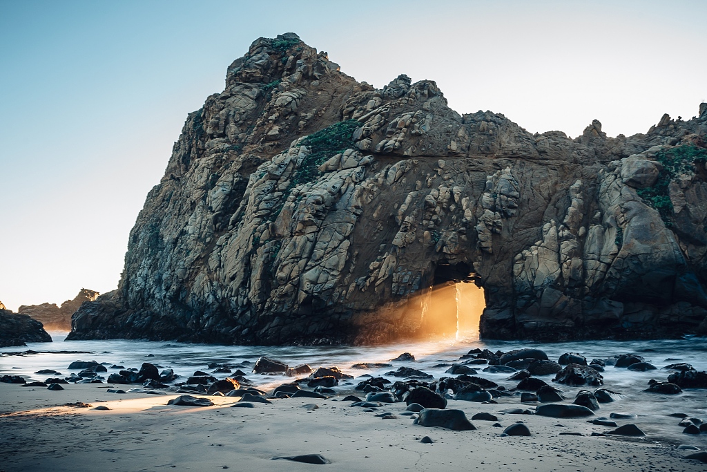 A beacon of light shines through a rock arch during a rare natural phenomenon at Pfeiffer Beach on California’s Big Sur coast, United States. /CFP