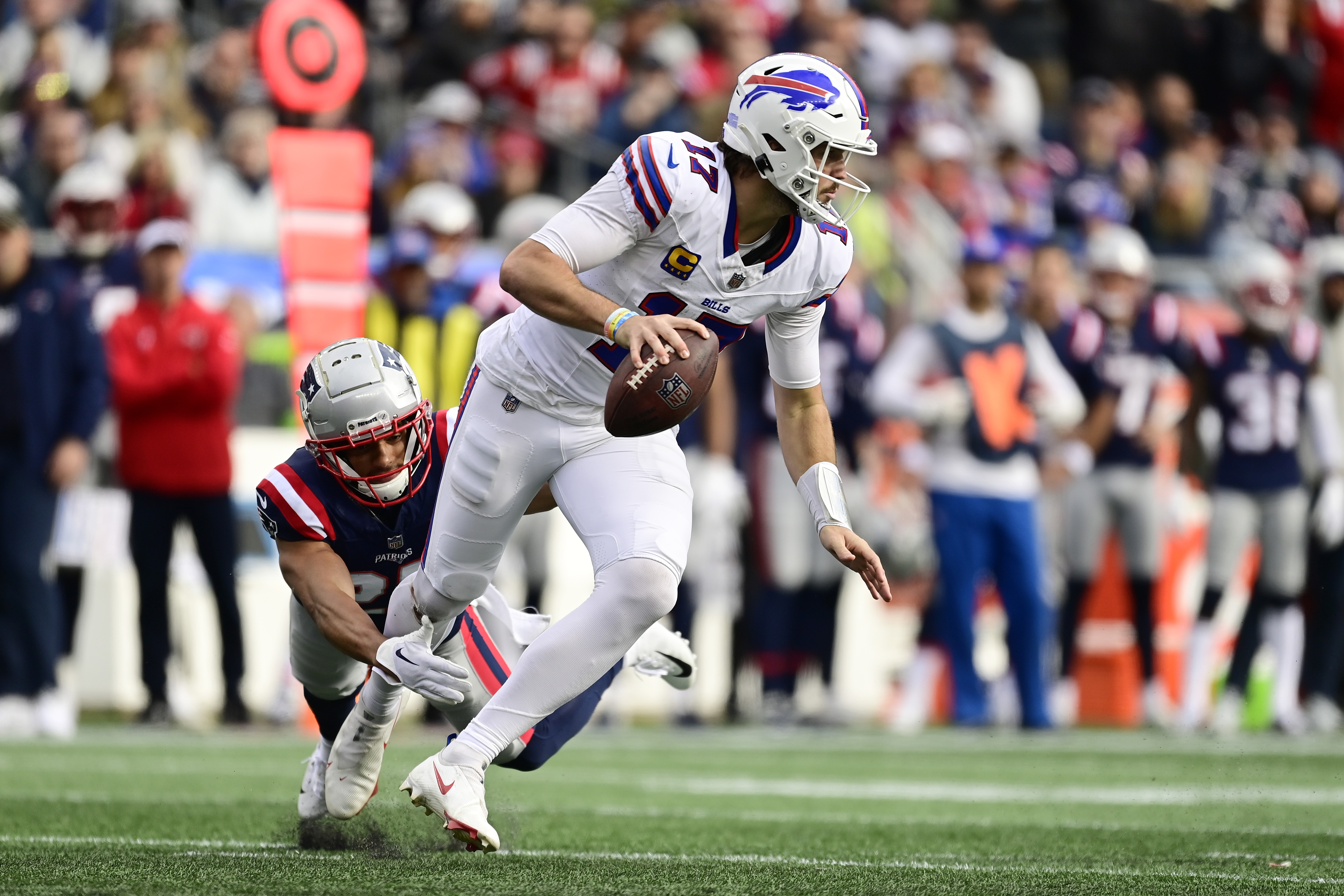 Quarterback Josh Allen (R) of the Buffalo Bills evades a tackle in the game against the New England Patriots at Gillette Stadium in Foxborough, Massachusetts, October 22, 2023. /CFP 