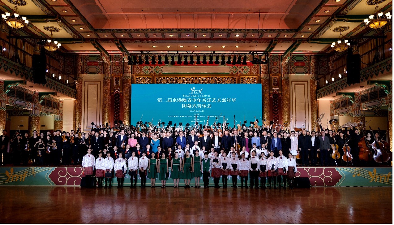 Nearly 300 members of a student symphony orchestra and two student choirs pose for a photo following a final concert to mark the end of a series of artistic exchange activities involving music enthusiasts from Beijing, Hong Kong and Macao on Oct. 15, 2023. /Photo provided to CGTN