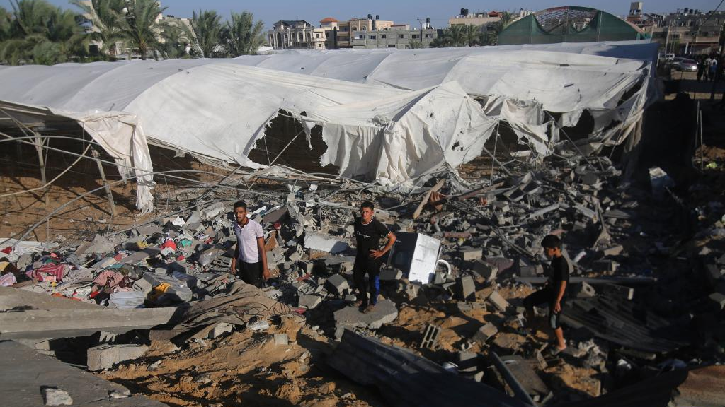 People stand among the rubble of a building destroyed in Israeli airstrikes in the southern Gaza Strip city of Rafah, October 20, 2023. /Xinhua