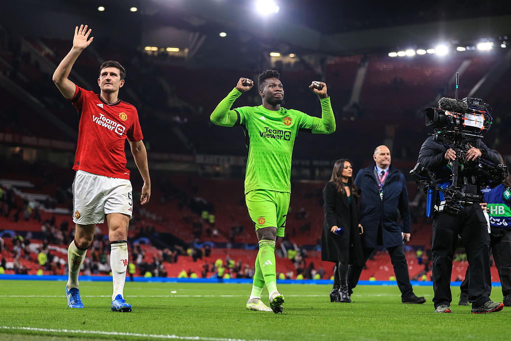 Manchester United's goalkeeper Andre Onana (C) and Harry Maguire (L) acknowledge the home crowd after their clash with Copenhagen at Old Trafford in Manchester, England, October 24, 2023. /CFP