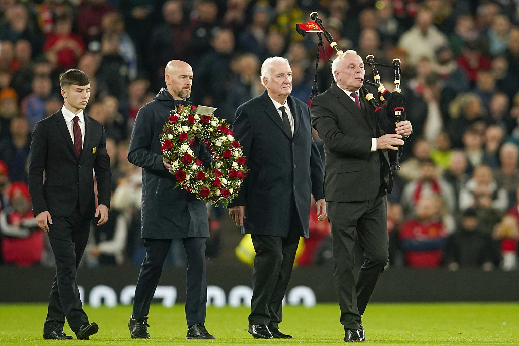 Manchester United manager Erik ten Hag (second left) lays flowers in memory of Sir Bobby Charlton prior their clash with Copenhagen at Old Trafford in Manchester, England, October 24, 2023. /CFP