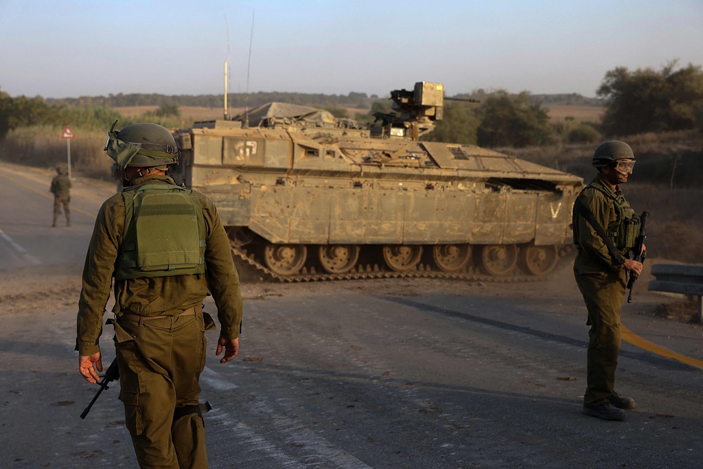 Israeli soldiers stand next to an armored personnel carrier as they hold a position near Sderot on the border with the Gaza Strip, October 25, 2023. /CFP