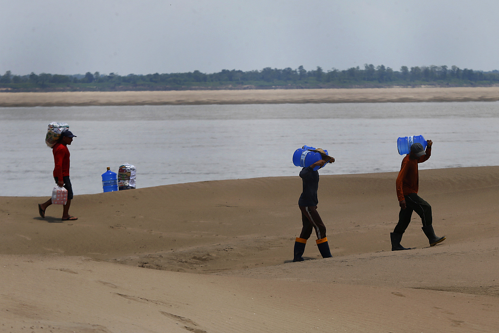 A resident of a riverside community carries a container of drinking water from an aid distribution site due to the ongoing drought in Careiro da Varzea, Amazonas state, Brazil, October 24, 2023. /CFP