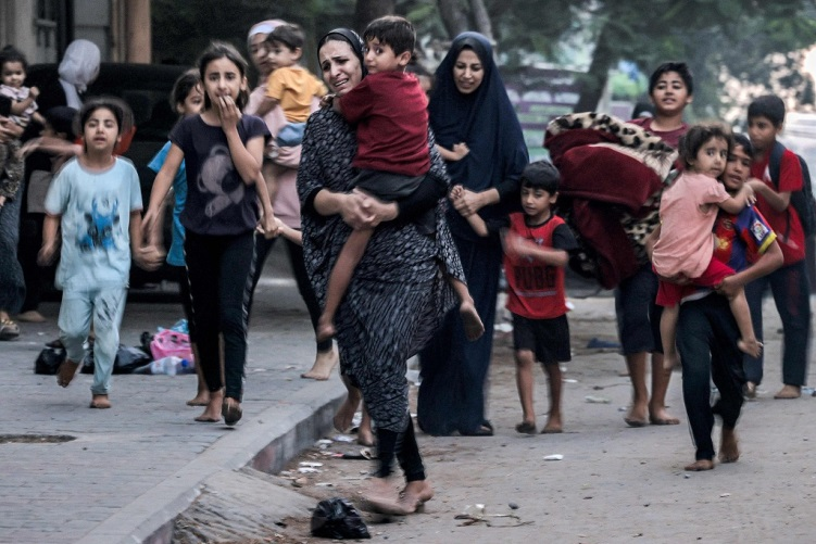 Palestinians fleeing from their homes following Israeli air strikes rush along a street in Gaza, October 11, 2023. /CFP